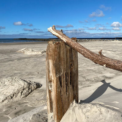 Træpæl med pind på stranden